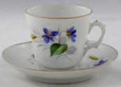 Coffee cup with blue flowers, cob and leaves