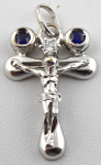 White gold cross with diamond and paired blue sapphires